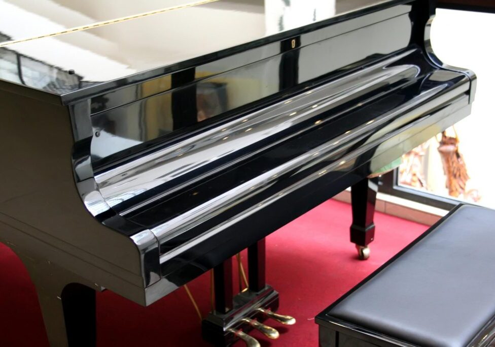 glossy black piano on red carpet